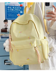 Detail of cute colorful butterfly embroidery on a light yellow canvas backpack