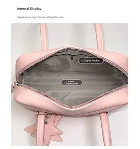 Vue intérieure du sac en similicuir rose montrant le compartiment zippé et le pendentif