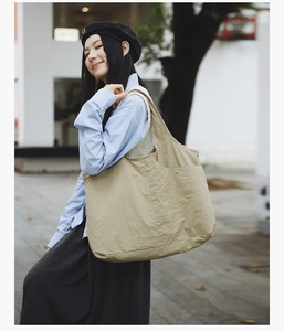 Détails du sac fourre-tout en nylon beige avec texture plissée et rivets métalliques