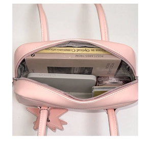 Vue intérieure du sac en cuir rose montrant la capacité pour livres et smartphone