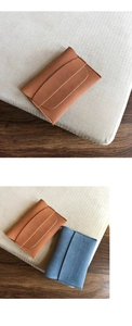 Close-up of minimalist matte suede coin purses in brown and blue with neat stitching
