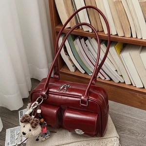Deep burgundy glossy shoulder bag with dual front pockets and plush bear charm