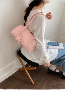 Sac baguette rose avec charm en forme d'étoile présenté dans un cadre de vie réel