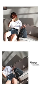 Detail of black nylon backpack with gold zippers shown in natural artistic light