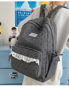 Detail of grey corduroy backpack with cute bear print, lace trim and plush ball accessory