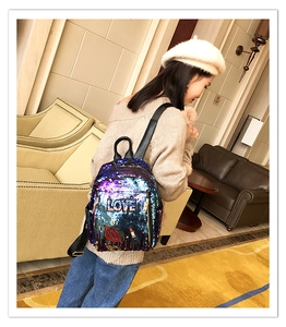 Fashion sequins backpack with love embroidery and glitter finish on model in a lounge