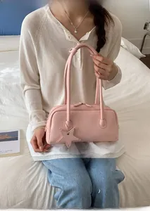 Détail du sac Boston rose pâle avec breloque étoile en cuir et fermeture éclair métallique