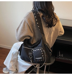 Detail of black canvas motorcycle bag with silver rivets and metal chain decoration