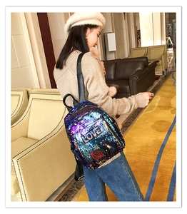 Close-up of the sequin backpack featuring LOVE embroidery and red lip pattern details
