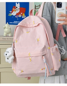 Pink school backpack with cute embroidery and decorative plush pendant detail