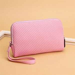 Detail of pink PU leather clutch with melon seed pattern and secure gold metal zipper