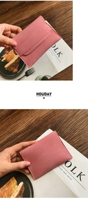 Detailed view of pink matte coin purse with multi-card slots on a textured wooden table