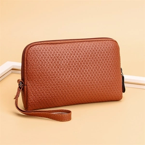Close-up of brown PU leather clutch bag with scale pattern embossing and wrist strap
