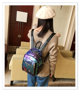 Detail of sequin mini backpack with LOVE embroidery and lip pattern on model