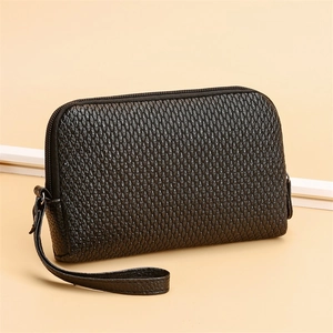 Close-up of black PU leather clutch bag with textured scale pattern and metal zipper