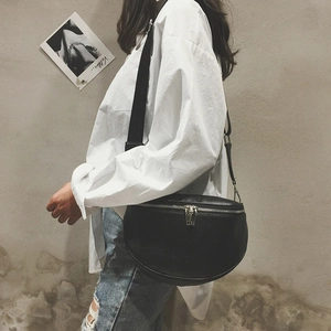 Minimalist black faux leather crescent chest bag with silver zippers and adjustable strap