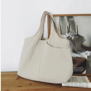Grand sac cabas en toile beige avec poche frontale pratique et boucle en métal élégante