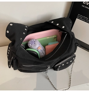 Macro shot showing large capacity of the black studded canvas bag with interior items