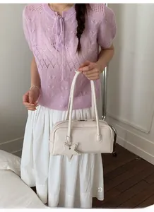 Détail du sac à bandoulière en cuir blanc crème avec pendentif étoile et longues lanières
