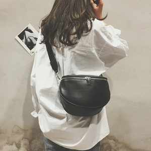 Detail view of a black semi-circular PU leather crossbody bag with silver double zippers