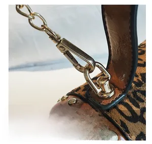 Detail der Tasche mit Leopardenmuster, goldener Kette und metallischen Nieten
