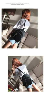 Détail du sac à dos en nylon noir avec fermetures éclair dorées au soleil