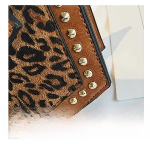 Detailansicht von Leopardenmuster mit braunem Wildlederbesatz und goldenen Nieten an Tasche