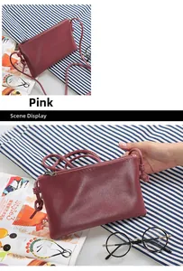 Detail view of pink crossbody bag with pebbled leather texture and knotted shoulder strap