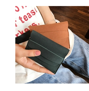 Detail of matte leather card holder wallets in dark green and brown with fine stitching