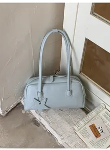 Détail du sac bandoulière bleu clair avec pendentif étoile et fermeture éclair double