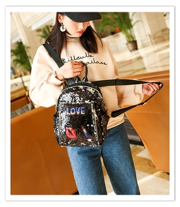 Close-up of black sequin backpack featuring LOVE embroidery and red lip fashion patches