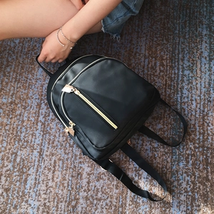 Classic black nylon backpack for women with shiny gold zippers in an everyday casual style