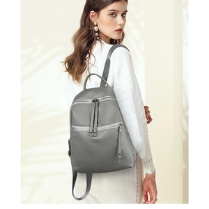 Detailed view of grey washed PU leather backpack with silver ring zippers on model