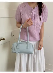 Détail du sac baguette en similicuir bleu clair avec un pendentif étoile élégant