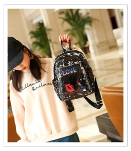 Detail of black sequined backpack featuring colorful LOVE embroidery and red lips patch