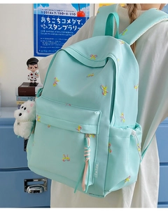 Detail of mint green school backpack with colorful bow embroidery and side logo label