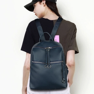 Detail of navy blue washed PU leather backpack with round ring zippers and side hook