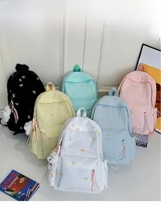 Close-up of colorful nylon backpacks featuring butterfly embroidery and plush charms