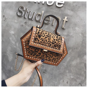 Detail einer sechseckigen Handtasche mit Leopardenmuster, Goldnieten und Kette