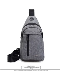 Detailed view of grey nylon chest bag featuring multiple zipper compartments and earphone port
