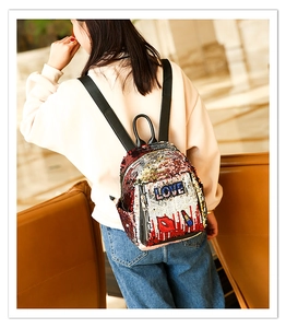 Detail view of the colorful sequin backpack featuring embroidered lips and LOVE letter design