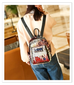 Close-up of sequin backpack with LOVE embroidery and lip pattern on model's back