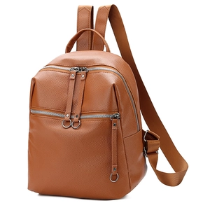 Detailed view of the brown PU leather backpack texture and circular ring zippers
