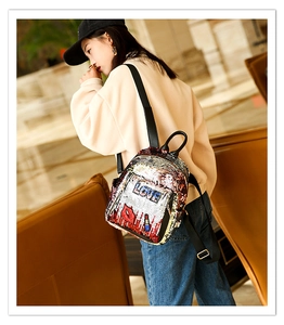 Lifestyle view of stylish sequin backpack with LOVE embroidery on a female model