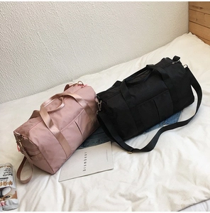 Close-up of pink and black waterproof oxford travel bags with reinforced handles and straps
