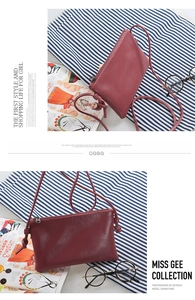 Detail of dark red lychee texture leather mini crossbody bag with metal zipper and strap