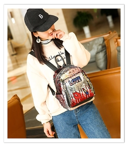 Detail of sequin backpack with LOVE embroidery and red lip patterns for teen girls