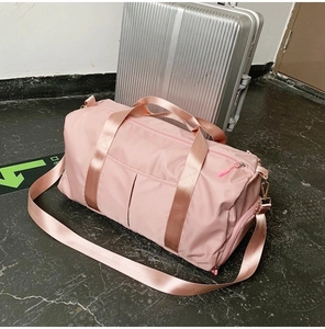 Pink waterproof travel bag showing side zipper shoe compartment and crossbody strap