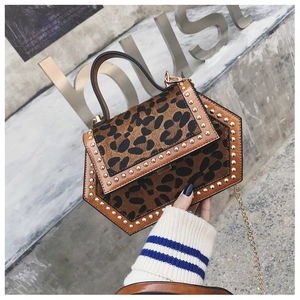 Detail einer Handtasche mit Leopardenmuster, Goldnieten und Hexagon-Design