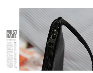 Close-up of premium black pebble leather texture and gunmetal zipper on the handbag